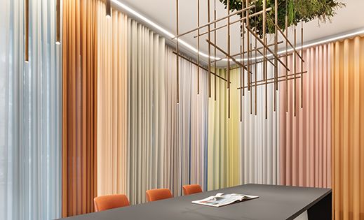 Showroom mit verschiedenfarbigen SERENO COLOR Vorhängen von Création Baumann.